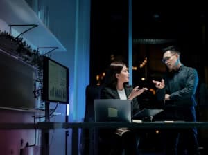 two people working at computer in dark, modern office