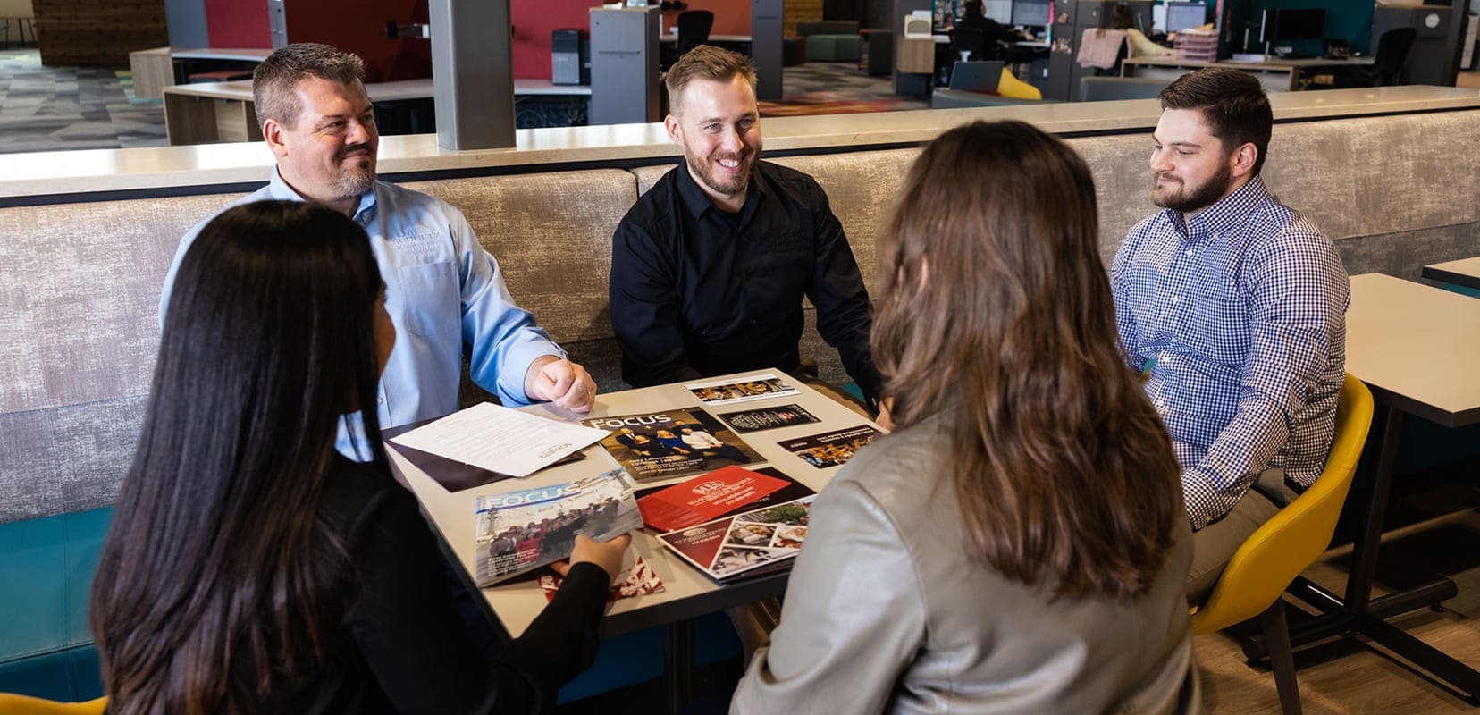 5 business leaders meeting over customer experience at a table