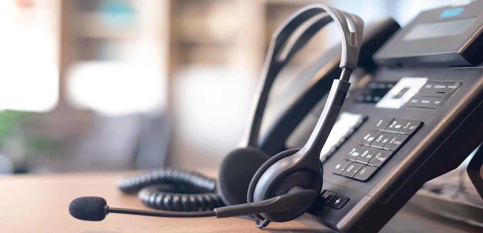 A black call headset and corded phone.